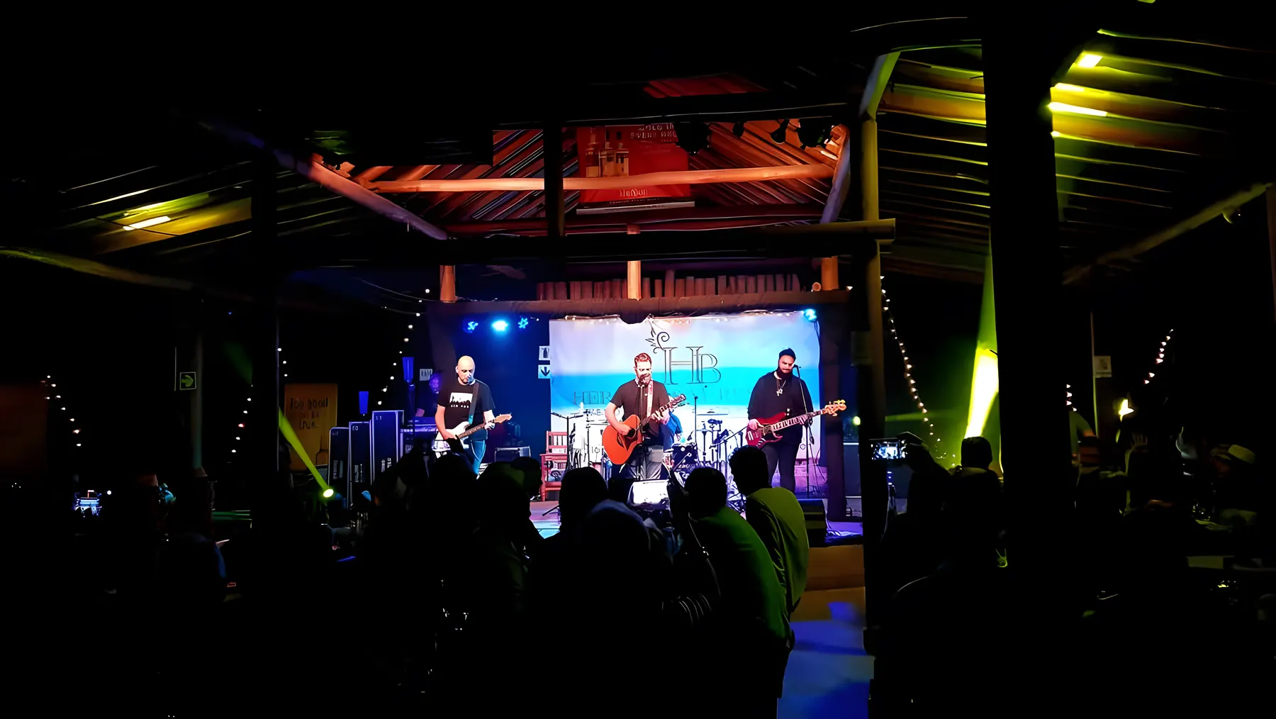 A band playing on the Bush Lapa stage under blue and green lights, with the crowd in front