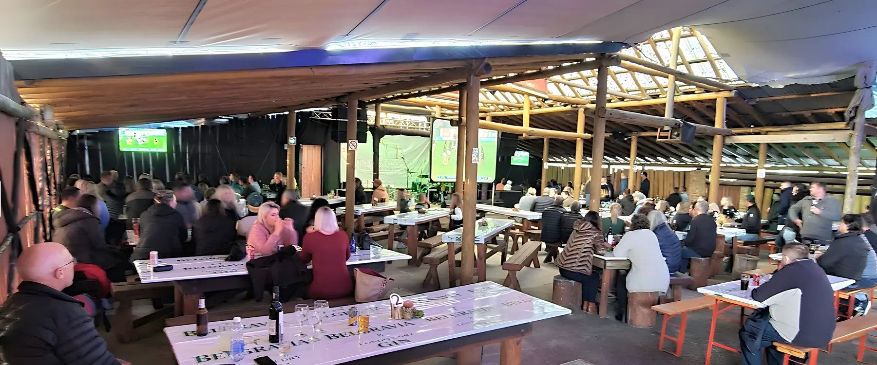 The Bush Lapa by day: long wooden tables under a timber and shade-cloth roof